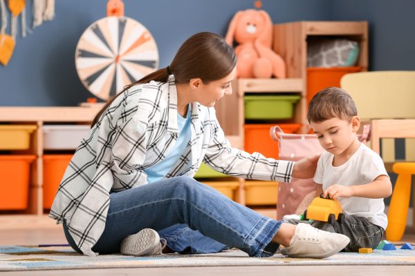 Nanny and cute little boy playing at home